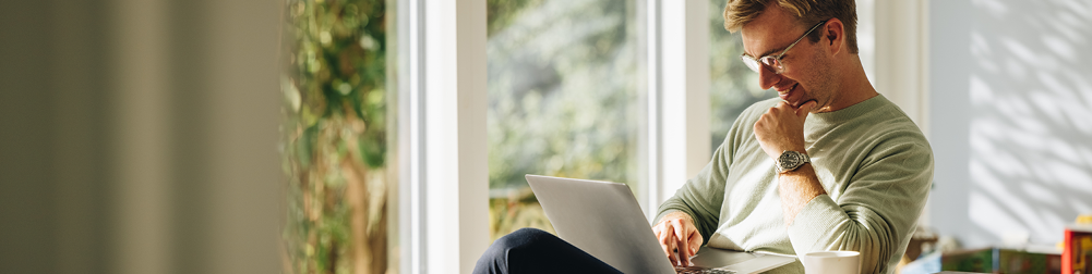 man at home looking at laptop