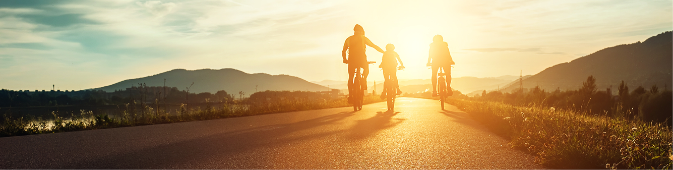 family biking on road during sunset
