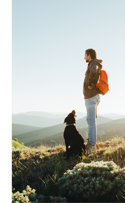 Man and his dog hiking, looking out over mountains