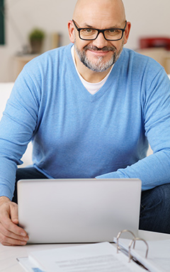 man in blue sweater at laptop