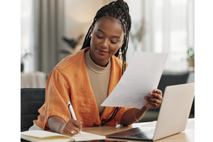 woman sitting at desk reviewing paperwork