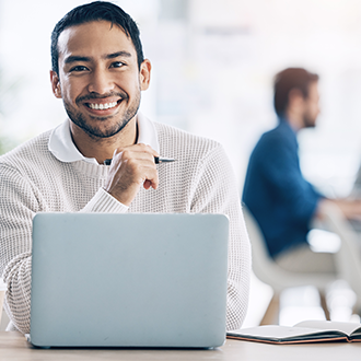 man smiling in front of laptop