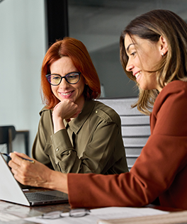 two woman looking at laptop