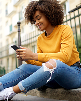 woman sitting outside looking at smartphone